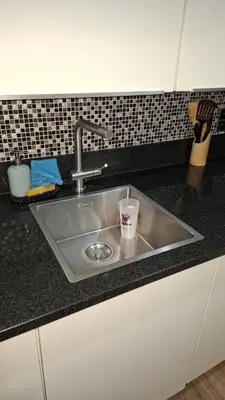 a kitchen sink with a cup in it at Chambres et appartement dans un immeuble in Brussels