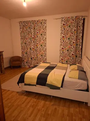 a bedroom with a bed and a large window at Chambres et appartement dans un immeuble in Brussels