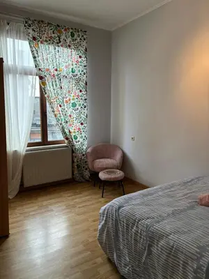 a bedroom with a bed and a chair and a window at Chambres et appartement dans un immeuble in Brussels
