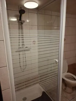 a shower in a bathroom with a toilet at Chambres et appartement dans un immeuble in Brussels