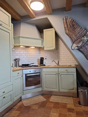 a kitchen with white cabinets and an attic at the hobbit house in Antwerp