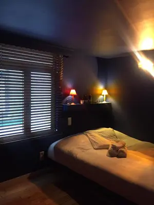 a bedroom with a bed with two lights on it at the hobbit house in Antwerp