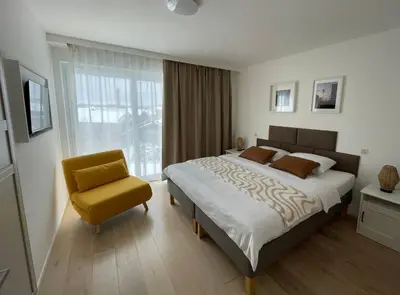 a bedroom with a bed and a yellow chair at Rooms Brussels Airport- 'The Good Place' in Zaventem