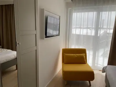 a yellow chair sitting in a room with a window at Rooms Brussels Airport- 'The Good Place' in Zaventem