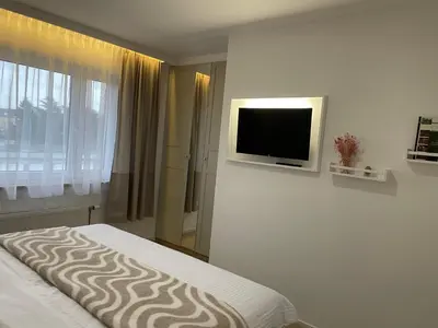 a bedroom with a bed and a tv on a wall at Rooms Brussels Airport- 'The Good Place' in Zaventem
