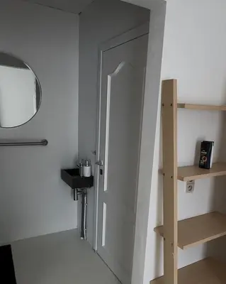 a room with a door and a mirror and a shelf at Antwerp West Side, Fireplace in Zwijndrecht