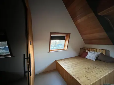 a small bedroom with a bed and a window at Vakantiewoning - Camping Groenpark in Berlare