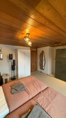 a large bed in a room with a wooden ceiling at Vakantiewoning - Camping Groenpark in Berlare
