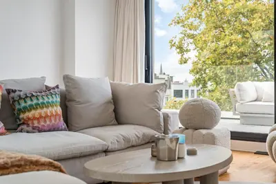a living room with a couch and a table and a window at Ultra-luxe penthouse, 3 slpks, toplocatie in Antwerp