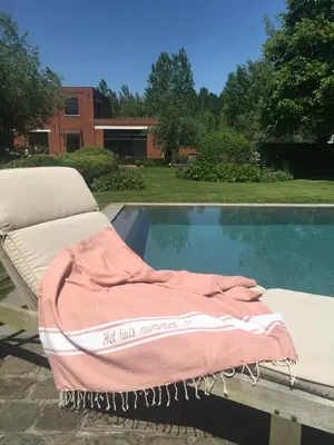 a blanket on a bed next to a swimming pool at Vakantiewoning HET HUIS NUMMER 11 in Oosterzele