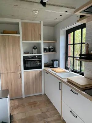 a kitchen with white cabinets and a counter top at Vakantiewoning HET HUIS NUMMER 11 in Oosterzele