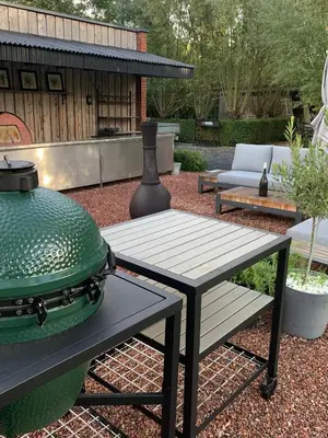 a grill sitting on a table next to a bench at Vakantiewoning HET HUIS NUMMER 11 in Oosterzele