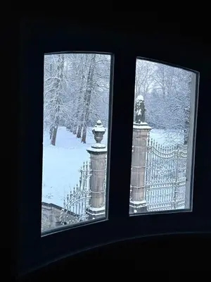 two windows with a view of a fence in the snow at Logies Het Koetshuis in Herentals