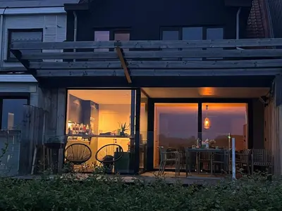a house with a patio with a table and chairs at Huisje Scheldevallei in Temse