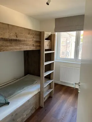 a bedroom with a bunk bed and a window at Huisje Scheldevallei in Temse