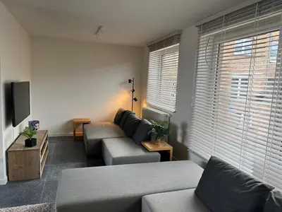 a living room with a couch and a tv at Huisje Scheldevallei in Temse