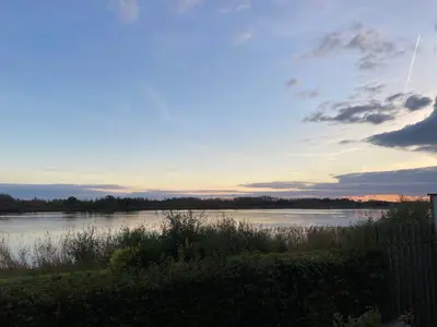 a view of a river at sunset at Huisje Scheldevallei in Temse