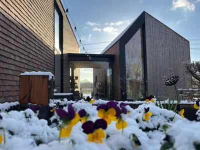a pile of snow covered flowers in front of a building at Bellefleur Cottage in Herent