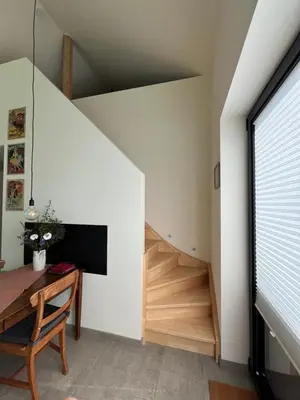 a staircase in a room with a table and a stair case at Bellefleur Cottage in Herent