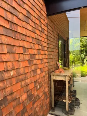 a brick wall with a table next to a window at Bellefleur Cottage in Herent