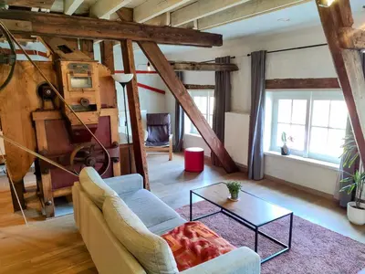 a living room with a couch and a table at Unique Historic Mill Loft with River Lys Views in Ghent