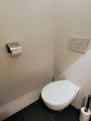 a bathroom with a white toilet in a room at Unique Historic Mill Loft with River Lys Views in Ghent