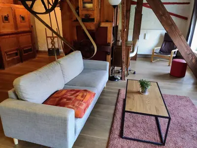a living room with a couch and a coffee table at Unique Historic Mill Loft with River Lys Views in Ghent