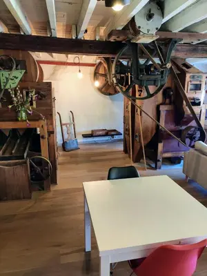 a white table and a chair in a room at Unique Historic Mill Loft with River Lys Views in Ghent