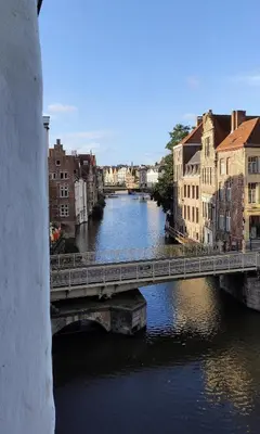 a bridge over a river in a city with buildings at Unique Historic Mill Loft with River Lys Views in Ghent