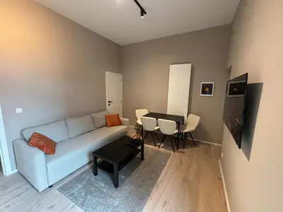 a living room with a blue couch and a table at Apartment central Lier in Lier