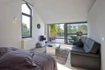 a bedroom with a bed and a couch and a television at Aan Den Oever Logies in Korbeek-Dijle