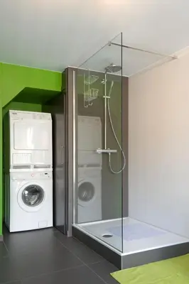 a bathroom with a washing machine and a washer at Aan Den Oever Logies in Korbeek-Dijle