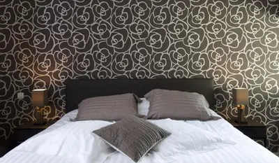 a bed with two pillows in a bedroom with a wallpaper at Aan Den Oever Logies in Korbeek-Dijle