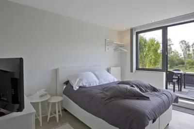 a bedroom with a bed and a large window at Aan Den Oever Logies in Korbeek-Dijle