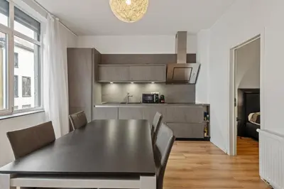 a kitchen and dining room with a black table and chairs at Antwerp Parkside apartments in Antwerp
