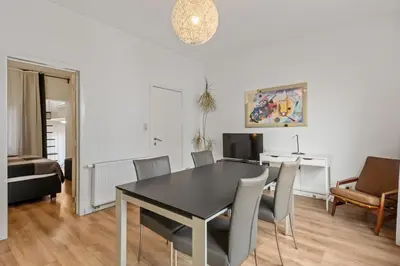 a dining room with a black table and chairs at Antwerp Parkside apartments in Antwerp