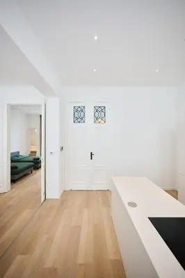 a white room with a white door and wooden floors at Louise City 2 in Brussels