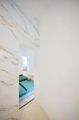 a bedroom with a bed in a room with marble walls at Louise City 2 in Brussels
