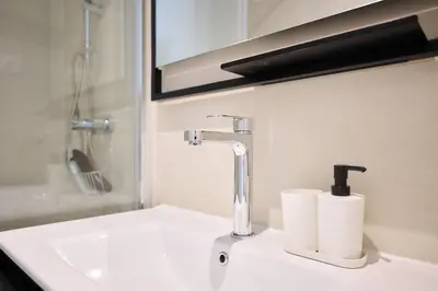 a bathroom sink with a faucet and two rolls of toilet paper at Apartement Berthelot 5 in Brussels