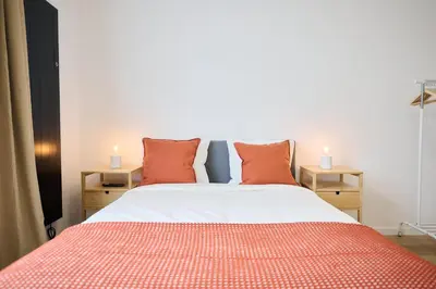 a bedroom with a large bed with orange pillows at Apartement Berthelot 5 in Brussels