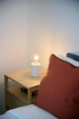 a lamp on a table next to a bed at Apartement Berthelot 5 in Brussels