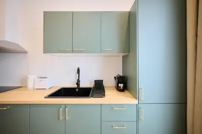 a kitchen with blue cabinets and a sink at Apartement Berthelot 5 in Brussels