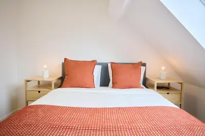 a bedroom with a bed with orange pillows at Apartement Berthelot 5 in Brussels