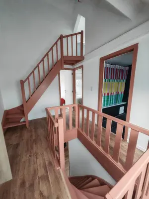 a spiral staircase in a room with a refrigerator at The Nest in Antwerp