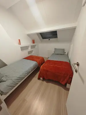 two beds in a small room with white walls at The Nest in Antwerp
