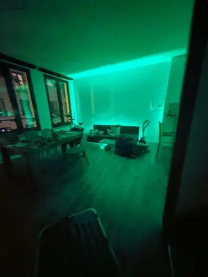 a dark living room with a table and chairs at The Nest in Antwerp