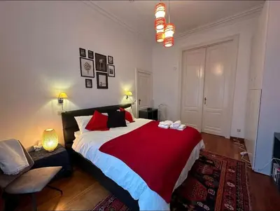 a bedroom with a large bed with a red blanket at Euro Edens Brussels - Cozy Family Suite in Brussels