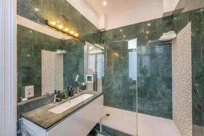 a bathroom with a sink and a glass shower at Euro Edens Brussels - Cozy Family Suite in Brussels