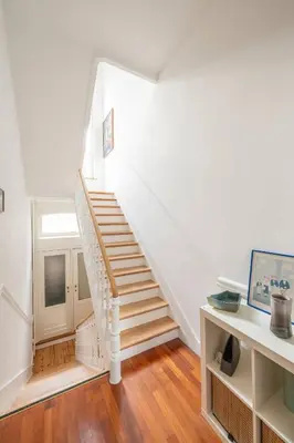 a white staircase in a room with wooden floors at Euro Edens Brussels - Cozy Family Suite in Brussels