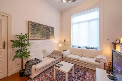 a living room with a couch and a tv at Euro Edens Cosy Historic Home in Brussels Jacuzzi, Garden, Central Location in Brussels